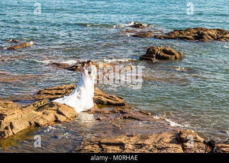 06-08-2016 - QINGDAO, CHINE - CHINOIS couple taking photos albums de mariage parmi les rochers de la côte de la baie de Qingdao Taiping Banque D'Images