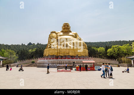 Jinan, Chine, avril 2015 - Les touristes à pied en face si la grande statue en or de Bouddha dans Qianfo Shan Banque D'Images