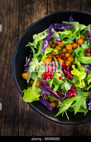 Bol de salade mixte avec des graines de grenade, le chou rouge et les pois chiches curcuma rôti Banque D'Images