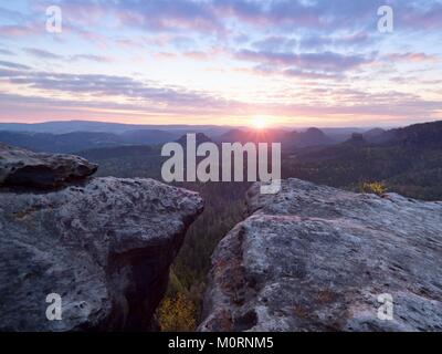 Matin vue sur falaise de grès dans la vallée brumeuse. Des pics de grès est passé de nuage brumeux, des couleurs chaudes. Banque D'Images