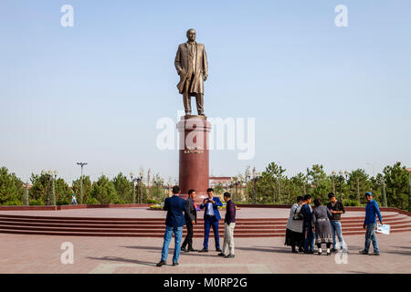 Peuple ouzbek posent pour une photo sous la statue de l'Islam Karimov, Samarkand, Ouzbékistan Banque D'Images