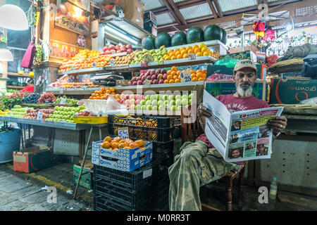 Articles mit Zeitung auf dem Zentralmarkt à Port Louis, Maurice, Afrika | vendeur de journaux de lecture sur le marché central de Port Louis, Maurice, Banque D'Images