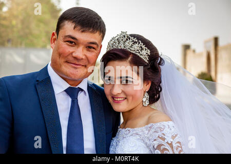 Un 'juste' jeune couple mariés posent pour des photos au complexe du Registan, le Reghistan, Samarkand, Ouzbékistan Banque D'Images