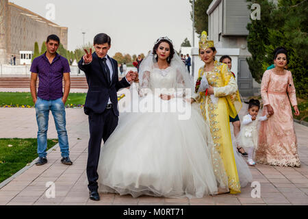 Un 'juste' jeune couple mariés posent pour des photos au complexe du Registan, Samarkand, Ouzbékistan Banque D'Images