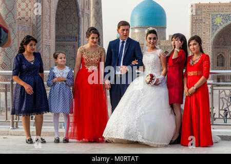 Un 'juste' jeune couple mariés posent pour des photos de mariage au complexe du Registan, Samarkand, Ouzbékistan Banque D'Images