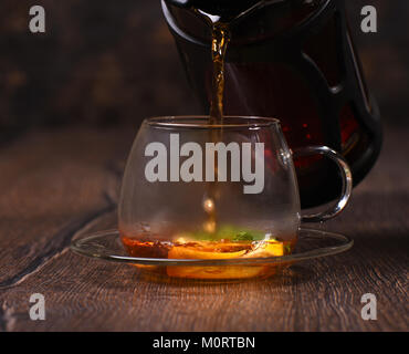 Le thé est versé dans une tasse de jus de citron et menthe Banque D'Images