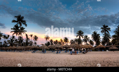 Une vue imprenable sur le coucher de soleil des Caraïbes sur Bavaro en République dominicaine, mettant en valeur des couleurs vibrantes dans le ciel et un cadre océanique tranquille. Cette scène capture la beauté naturelle et l'atmosphère sereine de la côte tropicale. Banque D'Images