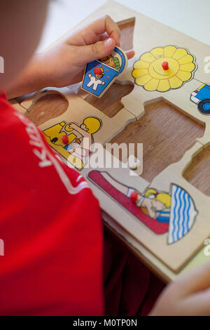 Enfant faisant un puzzle dans un jardin Banque D'Images