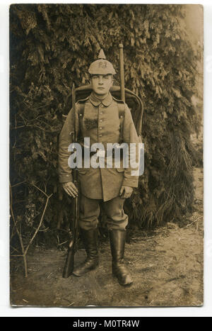 Vieille photographie allemande : un beau jeune soldat en pleine vitesse en uniforme militaire avec des armes, un fusil avec baïonnette couteau. La première guerre mondiale 1914-1918 Banque D'Images