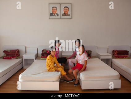 Les filles de la Corée du Nord dans une chambre sous les portraits officiels de la Chers dirigeants de Songdowon international children's Camp, province du Kangwon, Wonsan, la Corée du Nord Banque D'Images