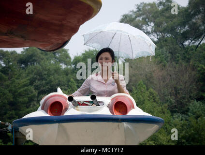 Femme de la Corée du Nord s'amusant sur une soucoupe volante attraction de Taesongsan fête foraine, de la province de Pyongan, Pyongyang, Corée du Nord Banque D'Images