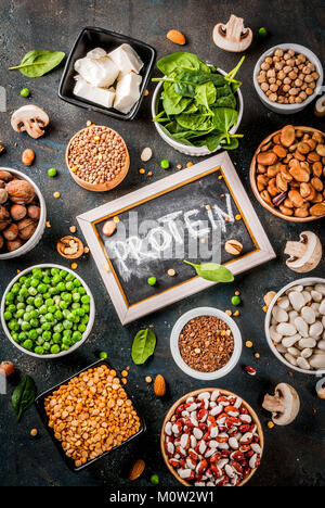 Régime alimentaire sain nourriture vegan, sources de protéines : Tofu veggie vegan, lait, haricots, lentilles, noix, lait de soja, les épinards et les graines. Vue de dessus sur le tableau blanc. Banque D'Images