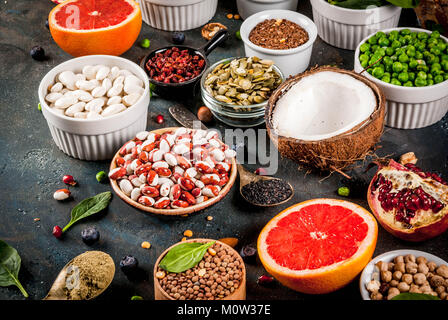 Ensemble d'alimentation saine, de l'alimentation biologique de l'air - Haricots, légumineuses, noix, graines, feuilles, fruits et légumes. Fond bleu foncé copy space Banque D'Images