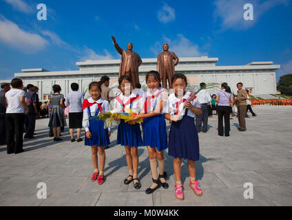 Pionniers de la Corée du Nord les filles de l'Union européenne, les enfants coréens devant les deux statues de la Chers Leaders dans le grand monument sur la colline Mansu, province de Pyongan, Pyongyang, Corée du Nord Banque D'Images