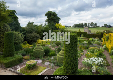 Une vue surélevée sur le jardin fleuri de Herterton House avec le grand gazebo en pierre en arrière-plan et la campagne au-delà, Northumberland, Angleterre. Banque D'Images