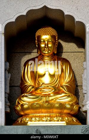 Statue en or de Bouddha assis dans une alcôve de pierre dans le célèbre Temple Siong Lim à Singapour Banque D'Images