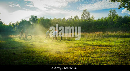 Daklak, Vietnam - Mai 10, 2015. Enfants jouant sur l'herbe poussiéreuse au champ campagne dans la province de Daklak, hauts plateaux du centre du Vietnam. Banque D'Images