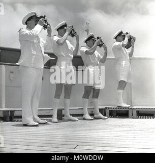 Années 1950, historique, quatre hommes en uniforme debout sur le pont d'un château-Union Steamship de marchandises et de passagers en pleine mer à destination de l'Afrique du Sud, prenant une vue' c.-à-d. contrôle de la position du navire, par l'aide d'instruments de navigation à vapeur. Banque D'Images