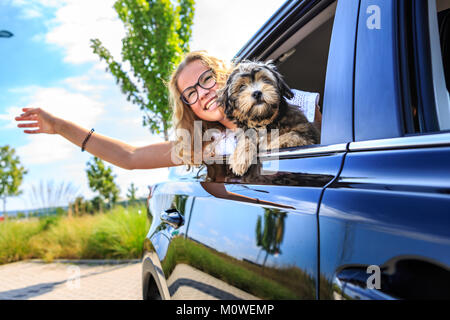 Une fille qui se déplacent en voiture avec sa famille et un chien Banque D'Images