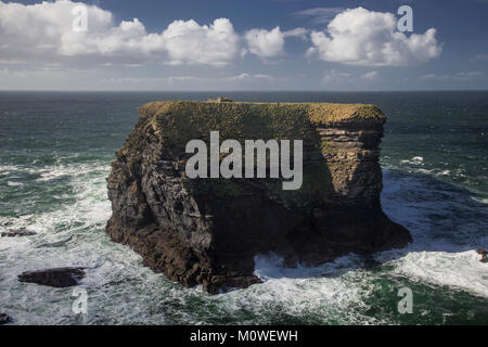 L'île des évêques sur l'Atlantique, côte ouest de l'Irlande à la tête de la boucle avec les vagues se briser autour de sa base Banque D'Images