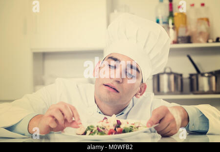 Cook est degustating plat préparé sur la cuisine. Banque D'Images