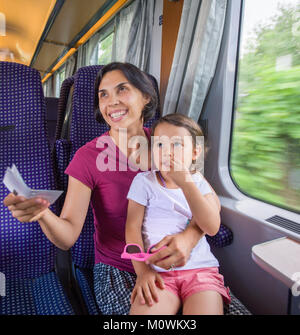 Femme et fille d'avoir son billet vérifié par le chef de train Banque D'Images