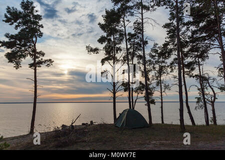 Une tente de couleur verte se trouve près de la forêt sur la rive. Tente à proximité de la forêt et l'eau. Banque D'Images