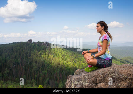 Jeune femme yoga méditation assis sur sommet de montagne rock Banque D'Images