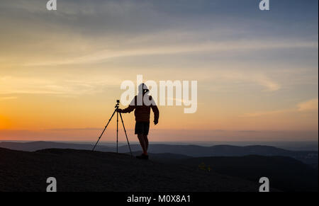 Silhouette de photographe de prendre une photo dans le coucher du soleil Banque D'Images