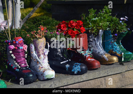 Vieux Bottes colorés recyclés dans les semoirs à jusqu'à un mur à RHS Garden Harlow Carr,, Harrogate, Yorkshire. UK. Banque D'Images