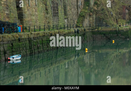 North Dock Seaham Harbour, Comté de Durham montrant l'âge du quai avec petit bateau et réflexion Banque D'Images