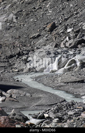 Une petite chute d'eau de fonte qui sortent de la base de la moraine terminale du glacier Franz Josef en Westland Tai Poutini National Park, NZ. Banque D'Images