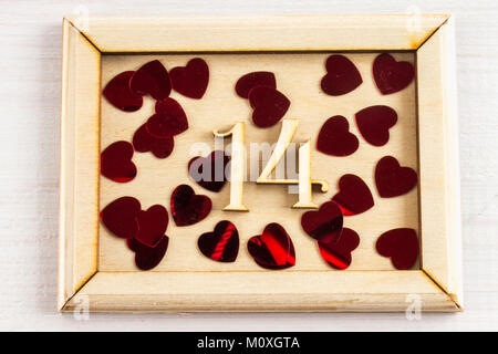 Cadre en bois avec des chiffres 1 et 4 et les cœurs sur une table en bois blanc. Le symbole de la journée des amoureux. Le jour de la Saint-Valentin. 14 février Concept Banque D'Images