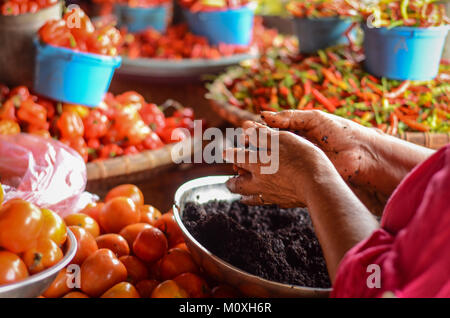 La main de vendeur d'épices en Bolu Pasar, un marché traditionnel de Toraja. Banque D'Images