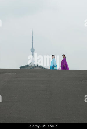 Deux femmes nord-coréen choson traditionnels en-ot en face de la tour de télévision, de la province de Pyongan, Pyongyang, Corée du Nord Banque D'Images