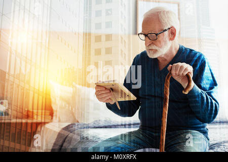 Le calme de personne assise et regardant la photo dans ses mains Banque D'Images