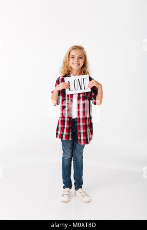 Portrait d'une jolie petite fille tenant feuille de papier avec une inscription isolée sur fond blanc d'amour Banque D'Images