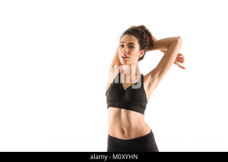 Smiling woman fitness échauffement en studio et regardant la caméra sur fond blanc Banque D'Images