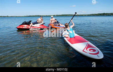 Les enfants s'amuser sur l'eau avec la paddleboard, Seadoo et radeau pneumatique. Clitherall Minnesota MN USA Banque D'Images