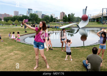 Visiteur au Walker Art Center de Minneapolis Sculpture Garden prend un avec Claes Oldenberg selfies Spoonbridge and Cherry. Minneapolis Minnesota MN USA Banque D'Images