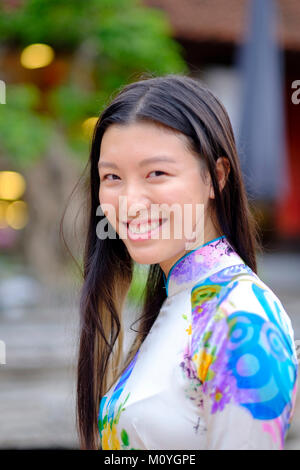 Vietnamese woman smiling et portant une robe traditionnelle Ao Dai Banque D'Images