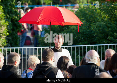 Allemagne, Cologne, culte d'ouverture du Congrès Eucharistique 2013 au Tanzbrunnen dans le quartier de Deutz. Avec les parapluies rouges les croyants sont Banque D'Images