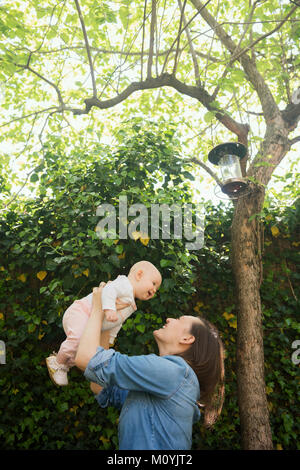 Mère de race blanche bébé fille en vertu de l'arbre de levage Banque D'Images