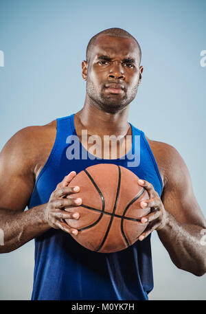 Confiant black man holding basketball Banque D'Images