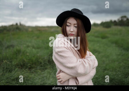 Asian woman standing in field Banque D'Images