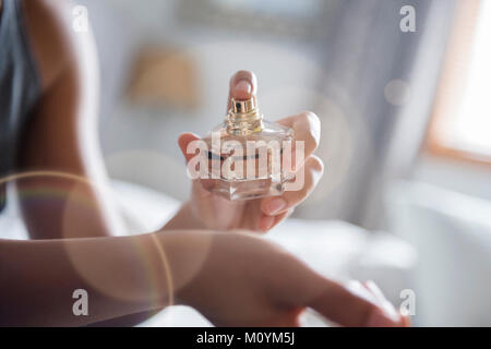 African American Woman spraying perfume sur poignet Banque D'Images