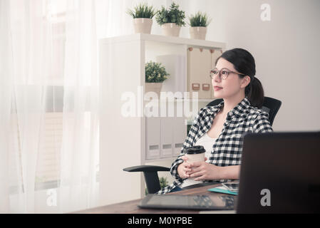 Belle femme élégante manager fini de travailler à la maison et de boire un café chaud à la fenêtre pour vous détendre au travail. en couleur film retro vintage Banque D'Images