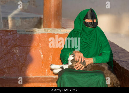 Nizwa, Oman, Décembre 15th, 2016 : Omani femme avec un bébé la chèvre le marché Banque D'Images