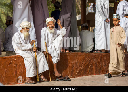 Nizwa, Oman, 23 juin 2017 : vieux hommes en costume traditionnel omanais socializing at un marché de chèvre Banque D'Images