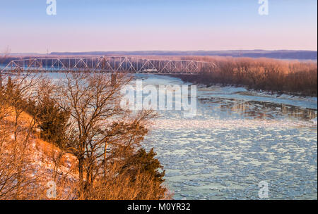 Vue de la rivière Missouri, au coucher du soleil au début du printemps ; flottantes de la rivière ; pont de l'autoroute à l'arrière-plan ; côte raide sur la gauche, Missouri Banque D'Images